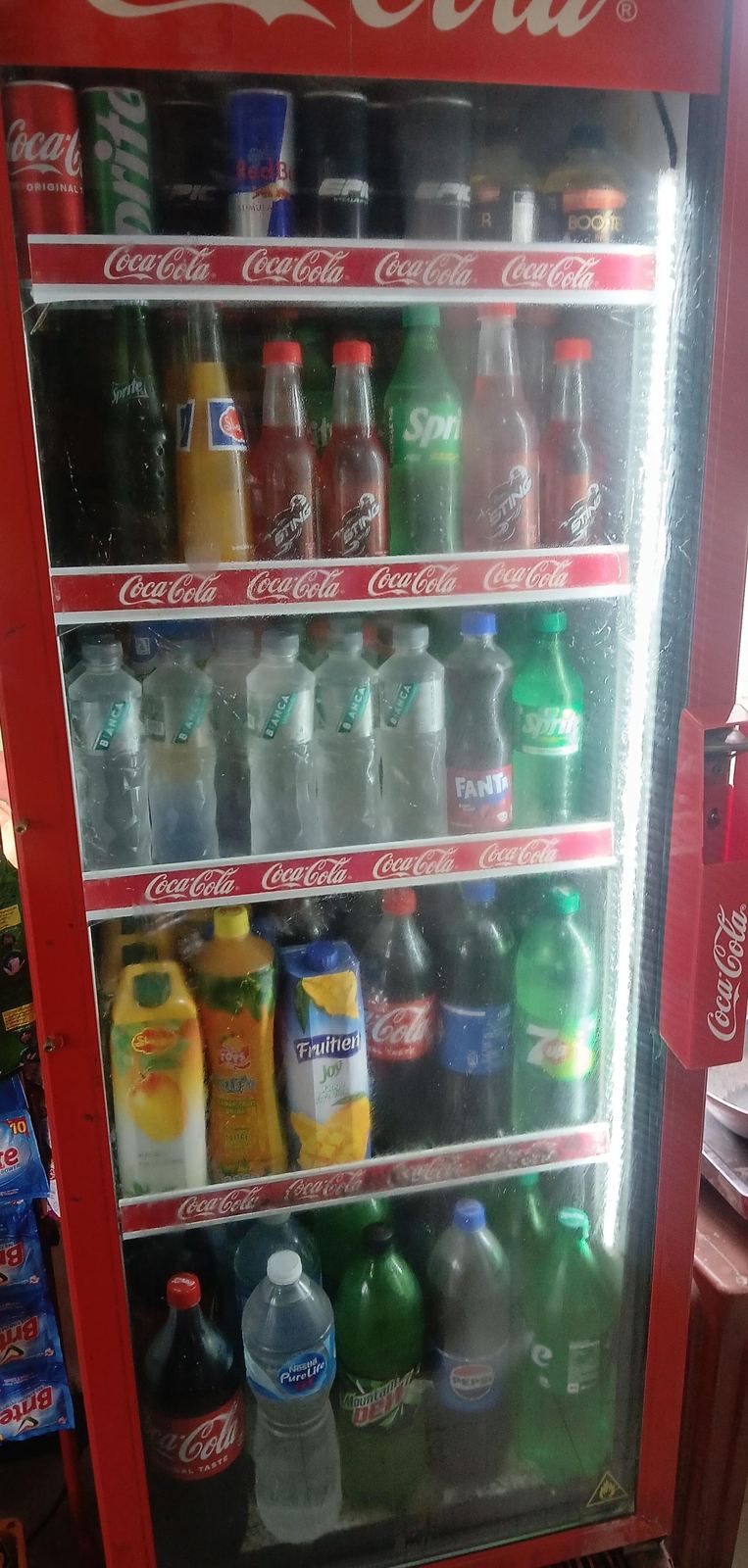 Cold drinks fridge stocked with soft drinks, juices and mineral water